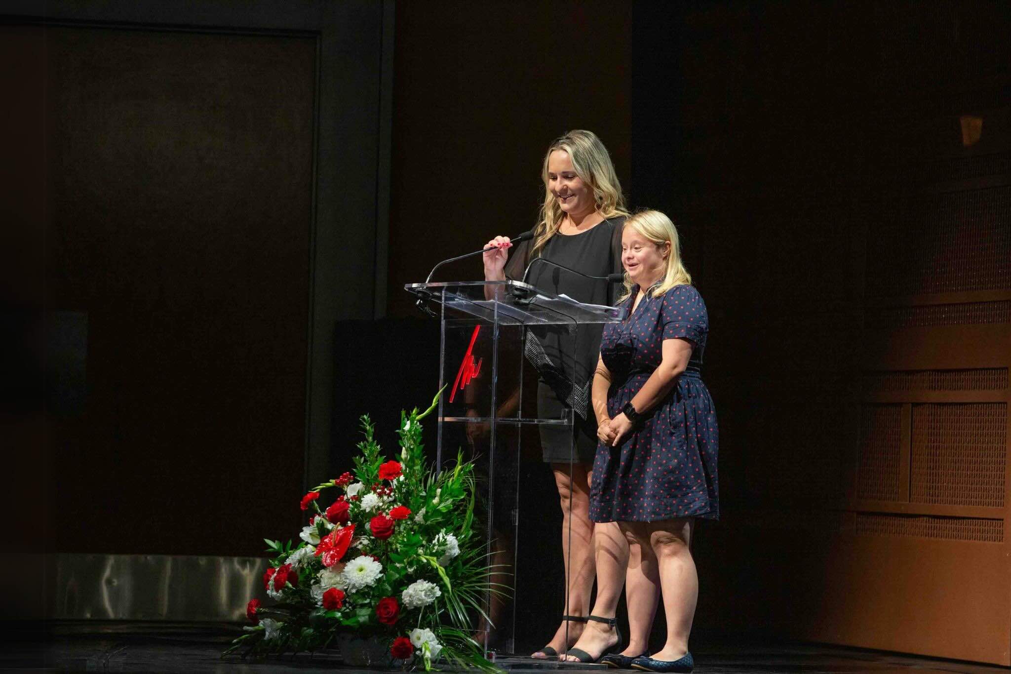 Two women present awards at the 2024 TPI Disability Summit.
